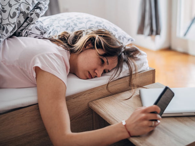 Tired woman lying across a bed